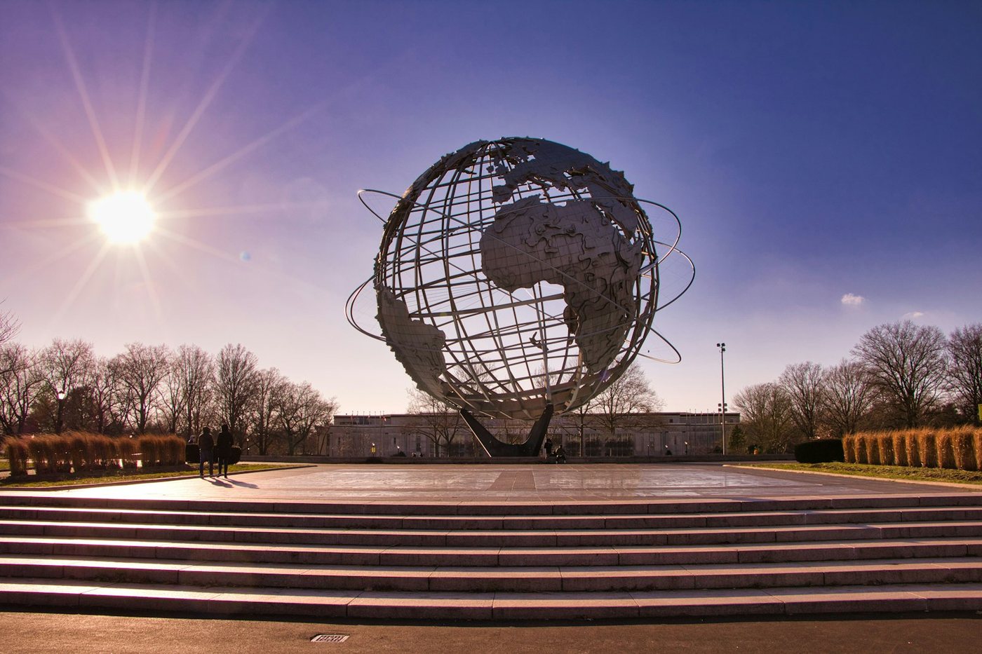 The Unisphere steel globe at Flushing Meadows Corona Park under a bright sun and a blue sky